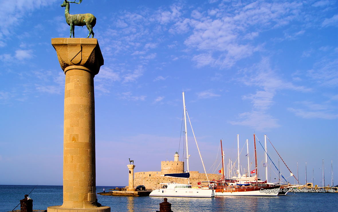 Rhodes Mandraki harbor with castle and symbolic deer statues, Greece